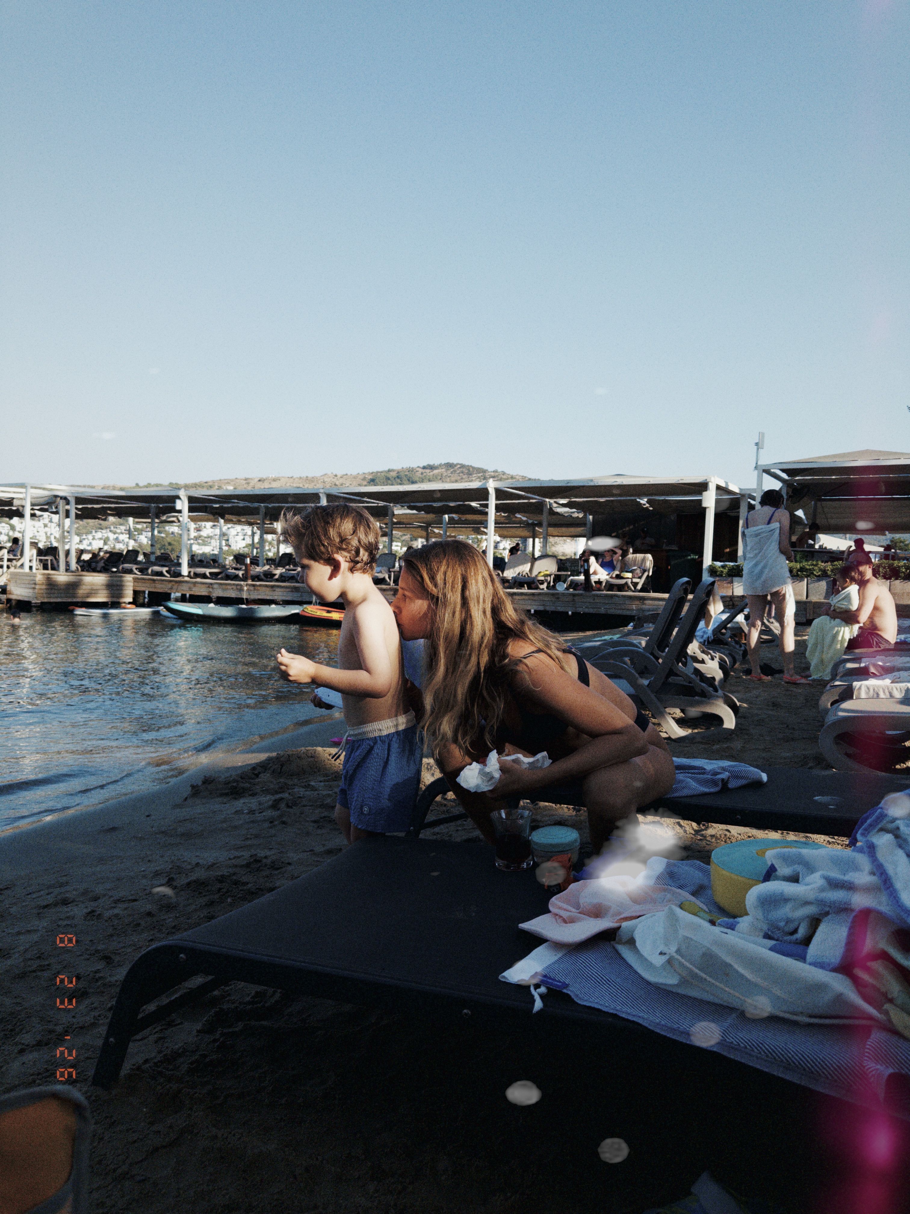 A woman and child together beside the sea, photographed with s’mple camera.